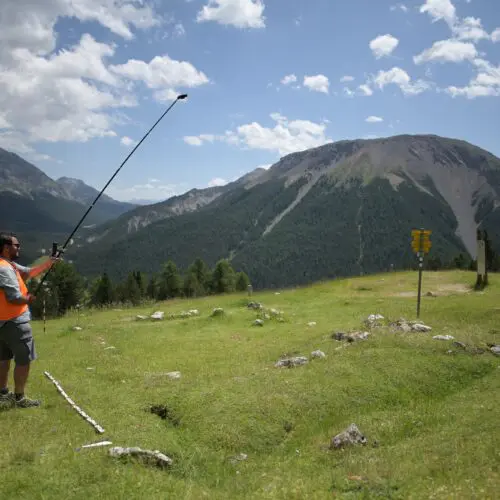 Ein Mitarbeiter des Archäologischen Dienstes Graubünden fotografiert die Ruine einer ehemaligen Alpweide auf Grimmels aus allen Richtungen.