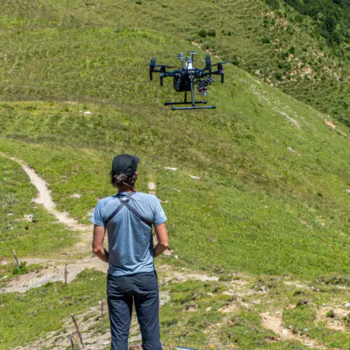 Ein SNP-Mitarbeiter fliegt eine Drohne an der Parkgrenze oberhalb der Alp Tavrü.