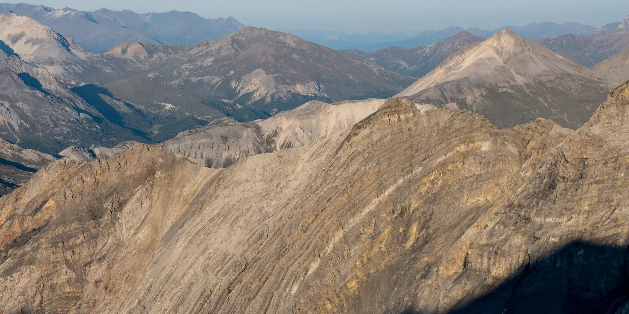 Aussicht über die Berggipfel mit gut sichtbarer Gesteins-Schicktung im Vordergrund